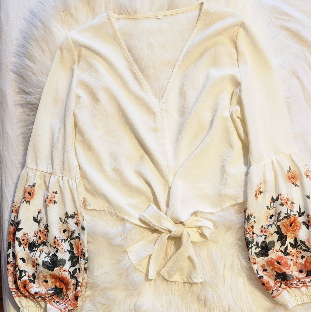 White top, with long sleeves, flower details on the bottom, size large